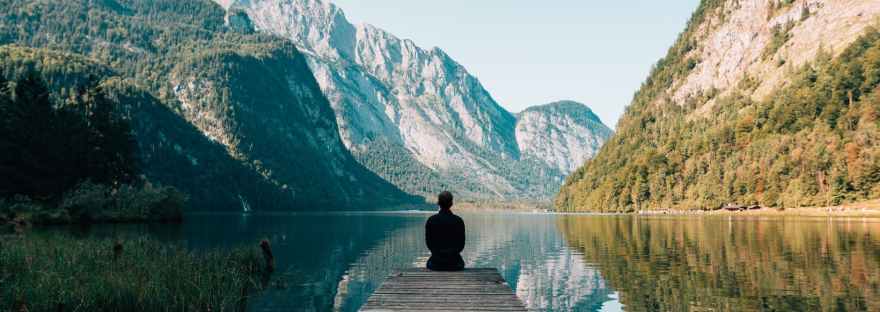 person on a bridge near a lake